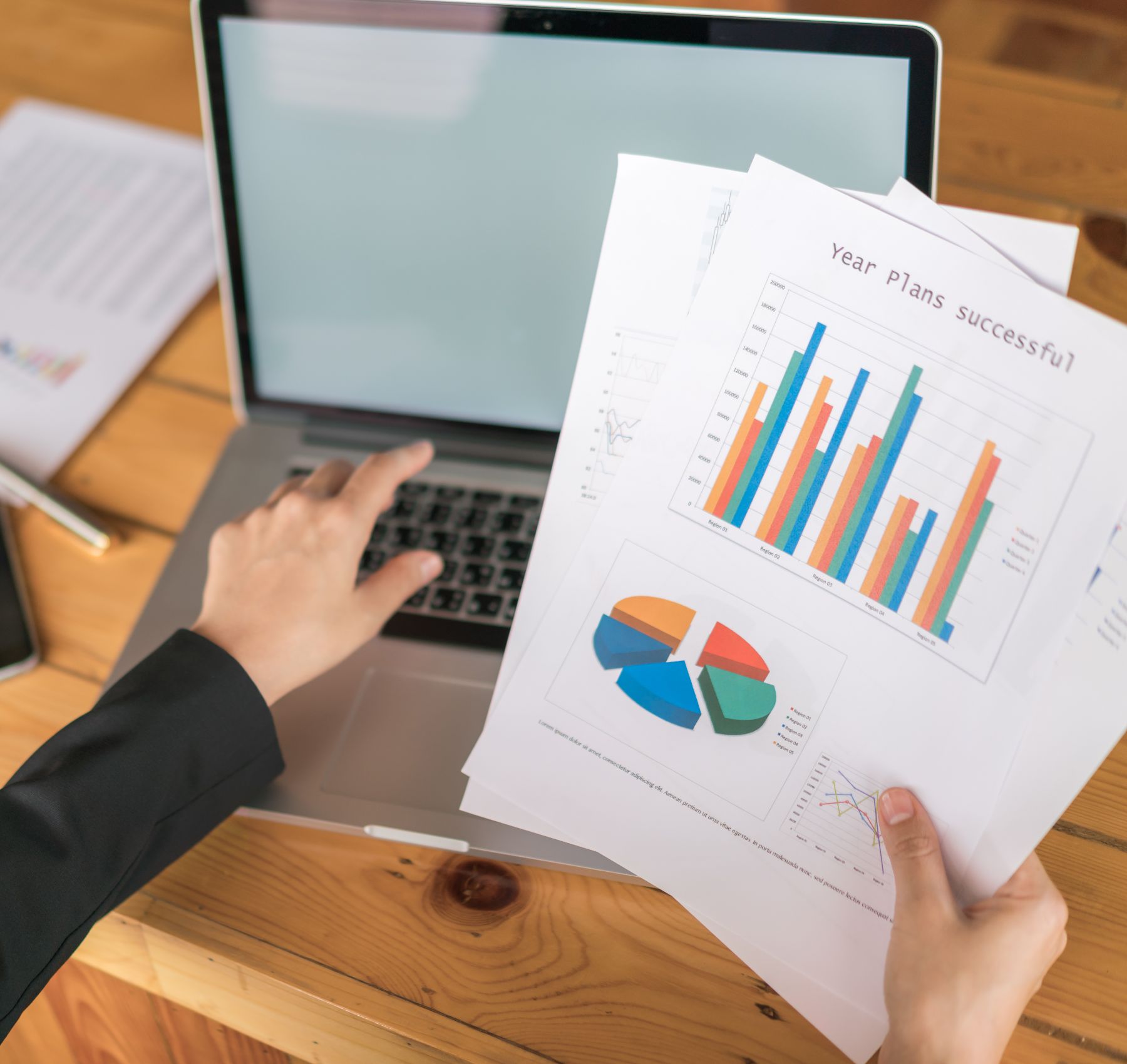 business-woman-hand-with-financial-charts-laptop-table-1